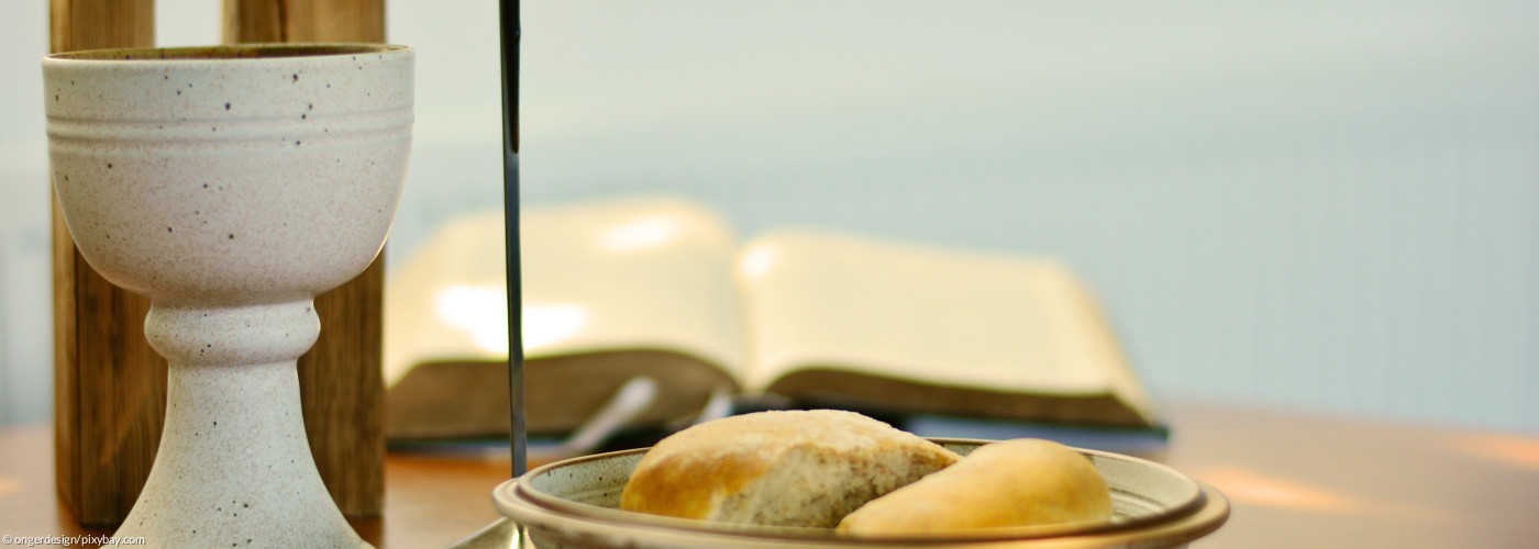 Abendmahlsgeräte auf einem Altar mit Kreuz