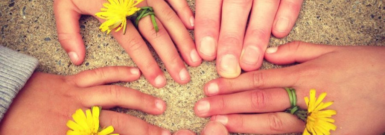 Kleine und große Hände mit gelben Einzelblüten sind kreisförmig angeordnet.